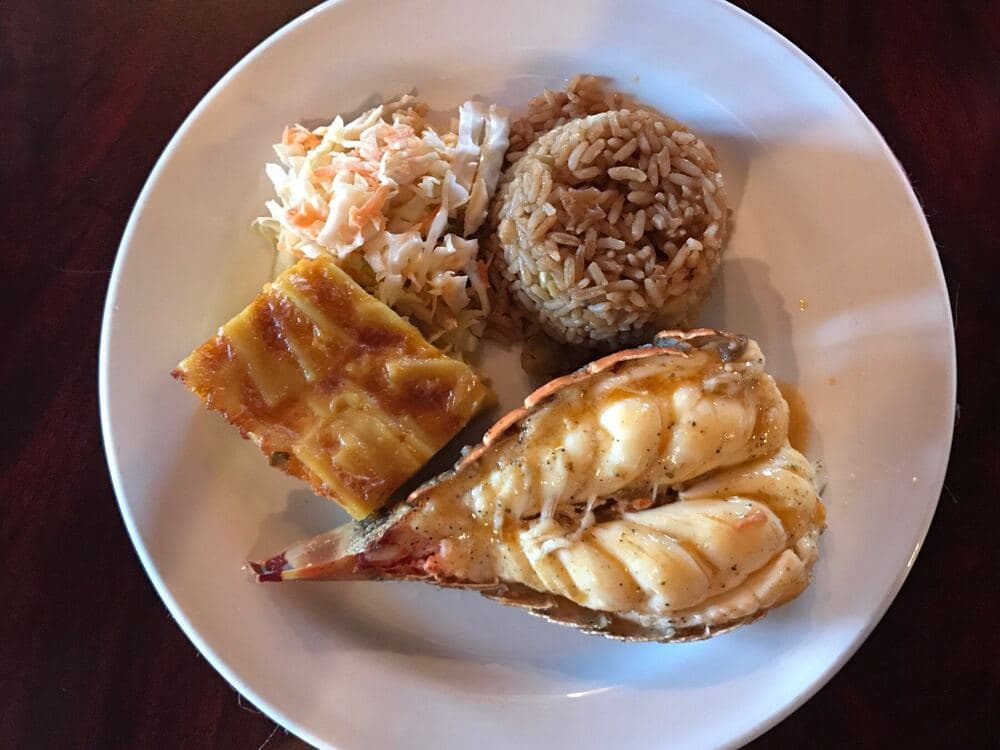A split lobster tail in butter, with peas 'n rice, mac and cheese and coleslaw.